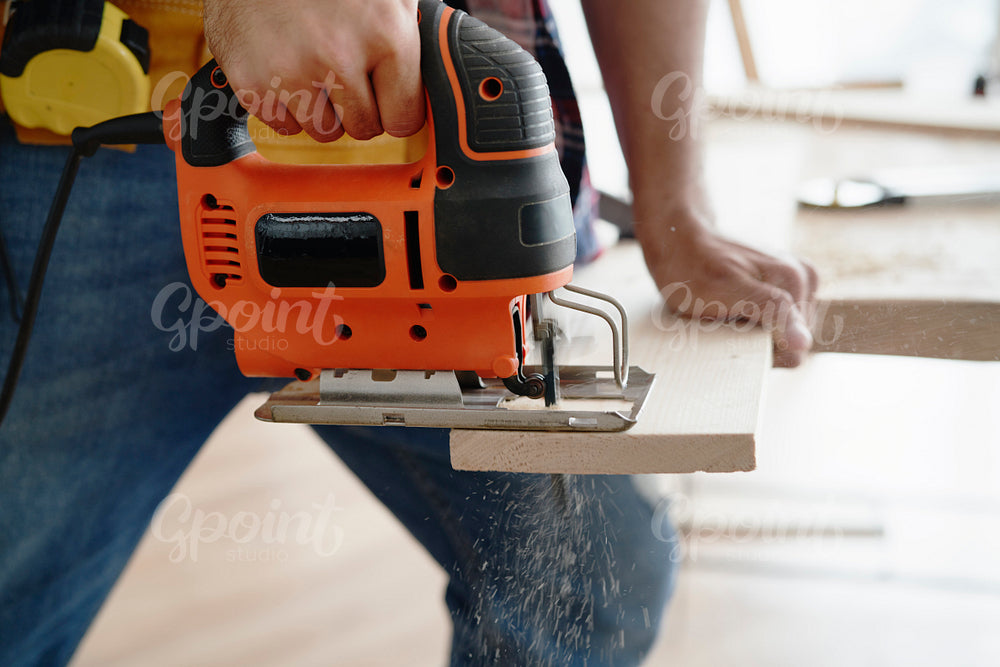 Close up of sawing wood with an electric jigsaw
