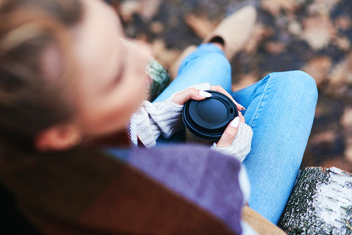 High angle view of woman with coffee relaxing in autumn