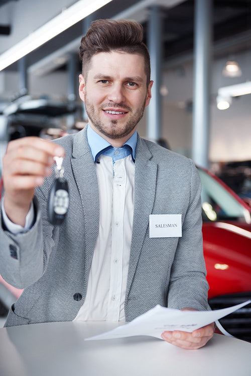 Salesman with car keys in front of the camera