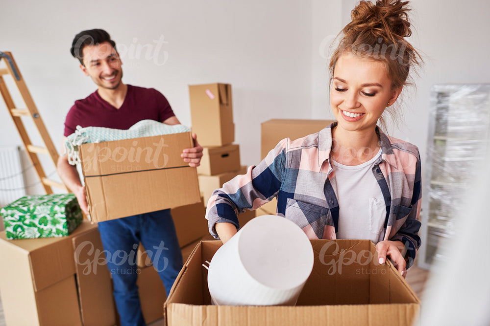 Couple packing their stuff into boxes during move house