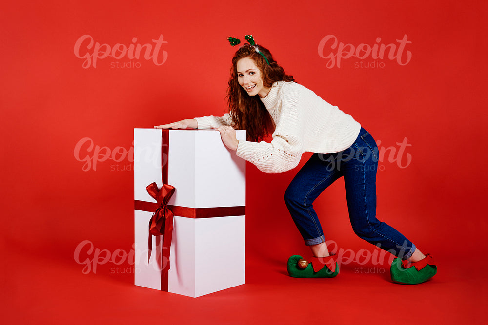 Woman carrying a big, christmas gift