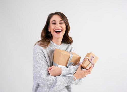 Beautiful woman holding two gifts in studio shot