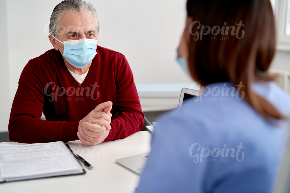 Senior patient in protective face mask in doctor's office