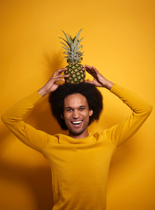 African man with an pineapple on his head