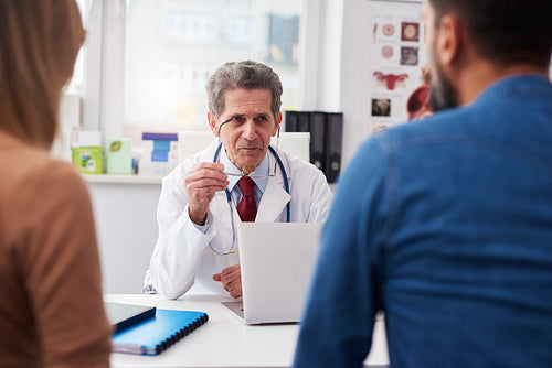 Couple talking with doctor in doctor's office