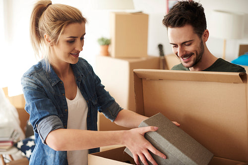 Couple organizing stuff from cardboard boxes