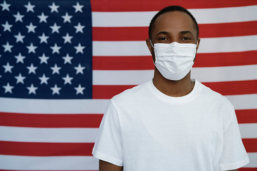 Black man with face mask on American flag background