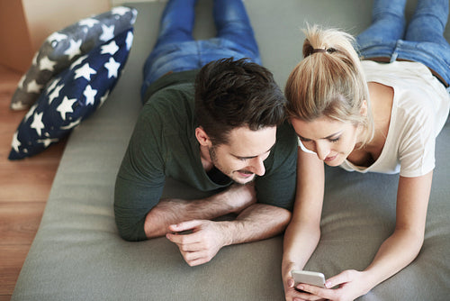 Couple using cell phone in their new home