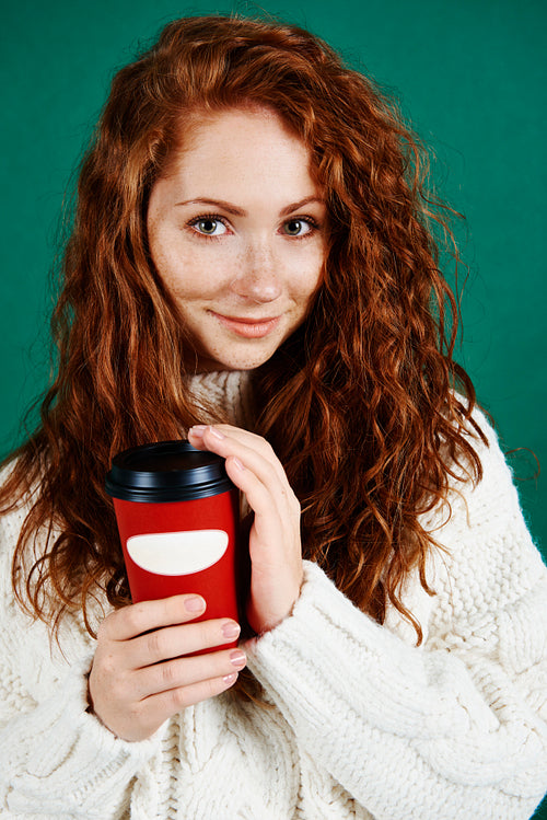 Beautiful woman holding disposable mug of coffee