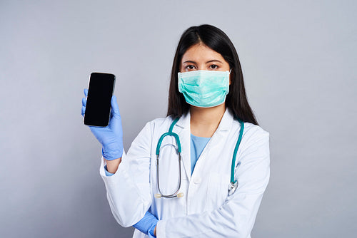 Asian doctor holding a mobile phone