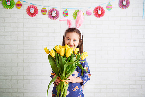 Happy girl holding bunch of yellow tulips