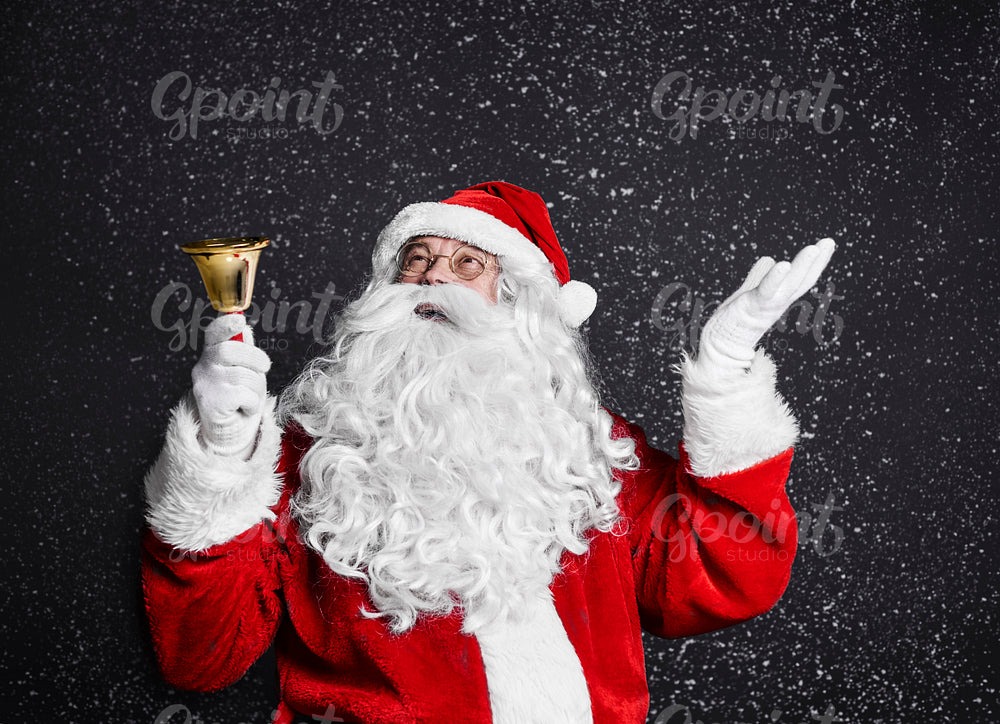 Santa claus with handbell among snow falling