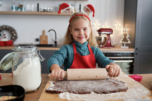 Portrait of girl rolling gingerbread dough
