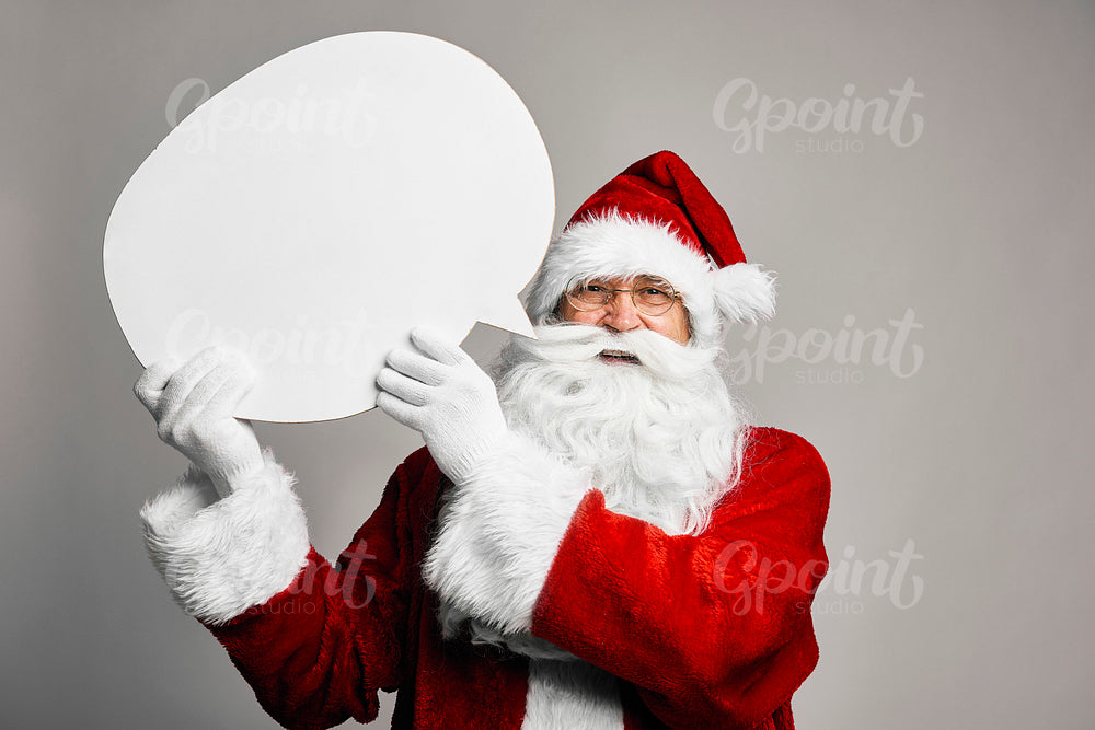 Caucasian Santa Claus on grey background holding a speech bubble 
