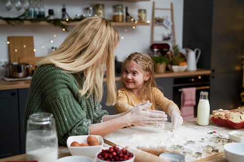Mom and little daughter playing with flour while baking