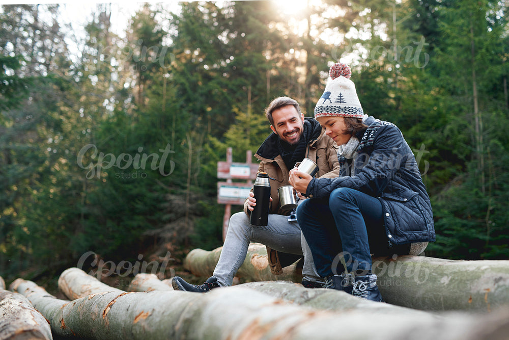 Father and son drinking hot tea in the autumn forest