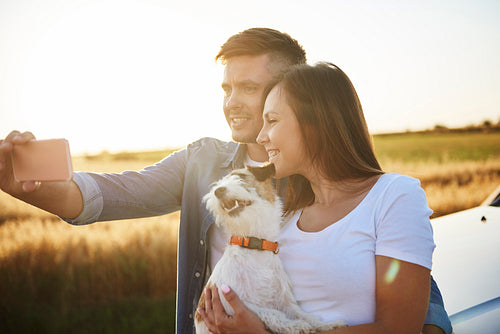 Young couple and their dog making selfie