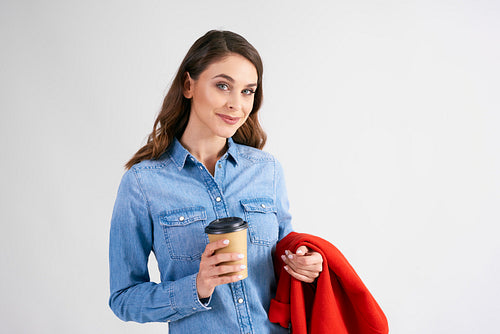Portrait of young woman with disposable cup of coffee