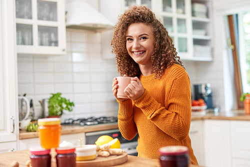 Portrait of smiling woman drinking tea in the kitchen