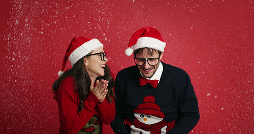 Happy nerd couple surrounded in snowflakes