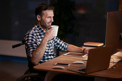 Side view of disabled businessman working late