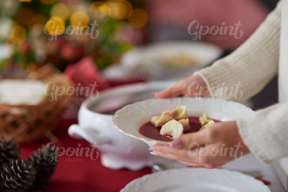 Woman holding a plate with beetroot soup