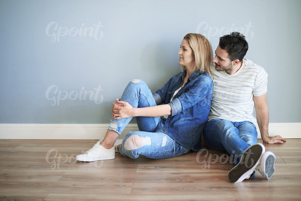 Young couple sitting on the floor of new house