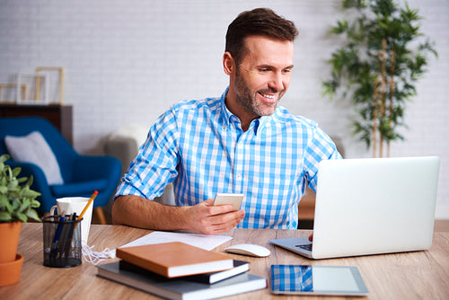 Smiling man working with laptop