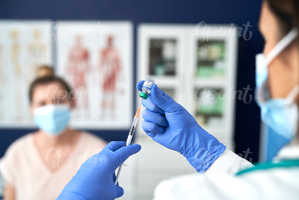 Close up of doctor preparing syringe for patient