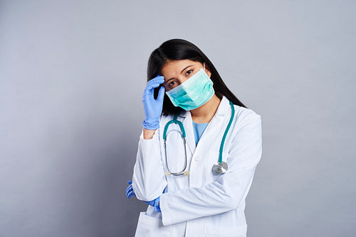 Tired female doctor in protective mask