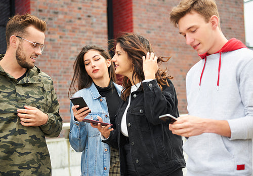 Young people using smart phones outdoors