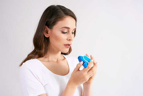 Young woman using an asthma inhaler