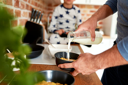 Close up of man preparing breakfast cereal for his son