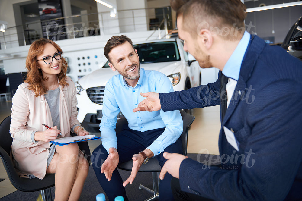 Woman signing the papers in the car dealership