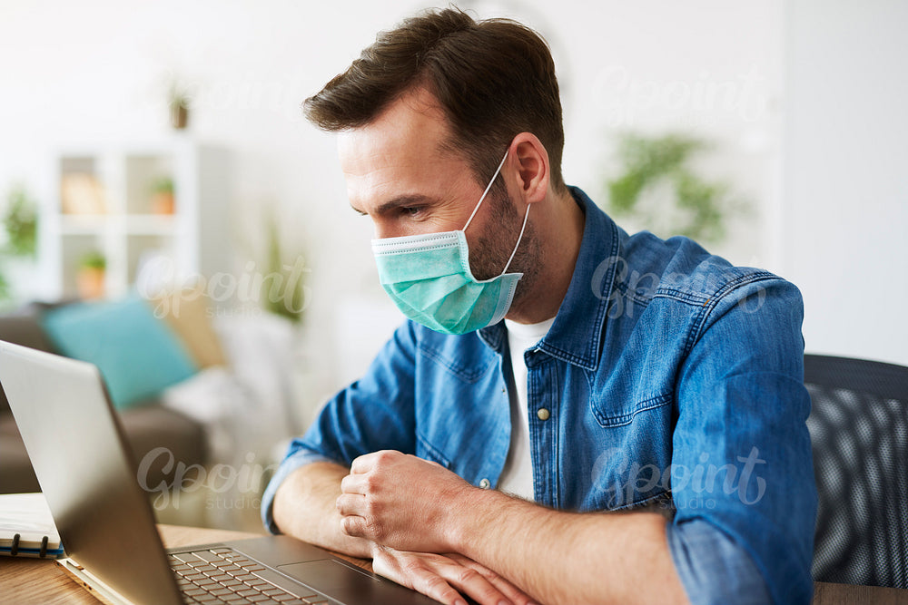 Freelancer working at home and wearing face mask