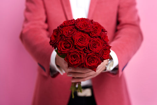 Unrecognizable man giving bunch of rose