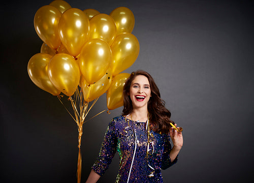 Beautiful woman with golden balloons in studio shot
