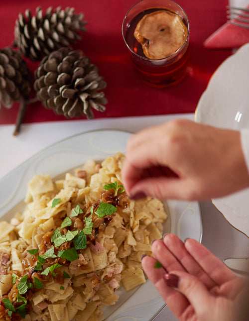 Decorating fettuccini with piece of herbs