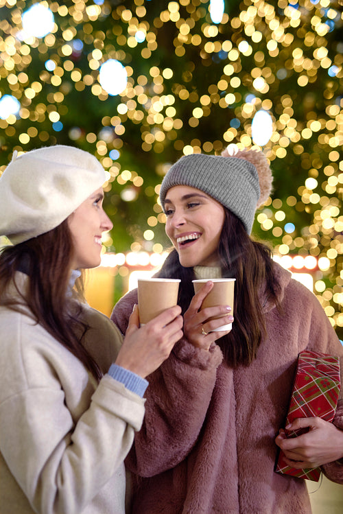 Vertical image of two women drinking mulled wine