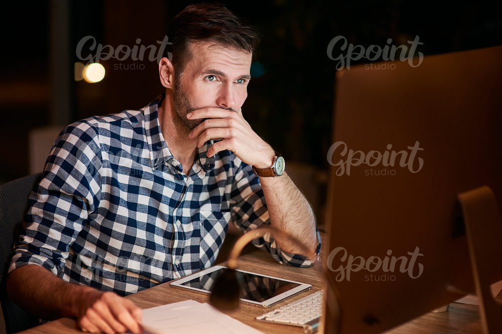 Focused businessman using a computer at night