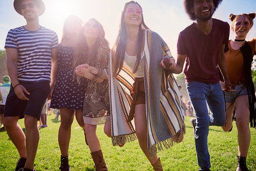 Group of happy people running at the music festival