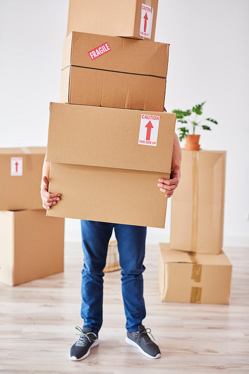 Man holding stack of boxes in front of his face