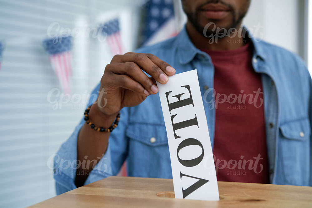 Black man giving his vote into ballot box