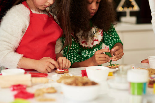 Two girls decorating Christmas cookies