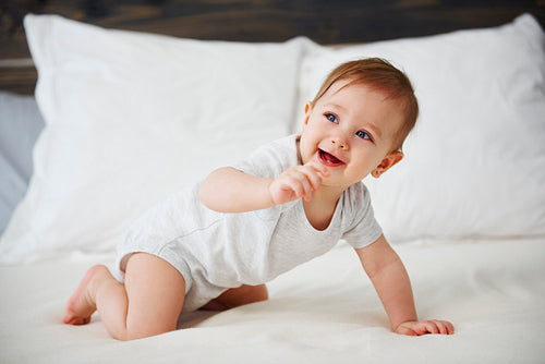 Happy baby crawling on the bed