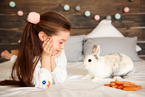 Cheerful girl looking at rabbit