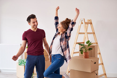 Cheerful couple having fun in their new apartment