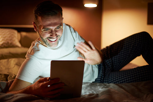 Happy man during video conference at night
