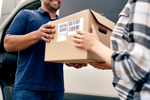 Close up of courier giving  a package to a customer