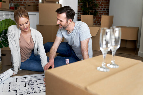 Couple sitting on the floor and planning new flat